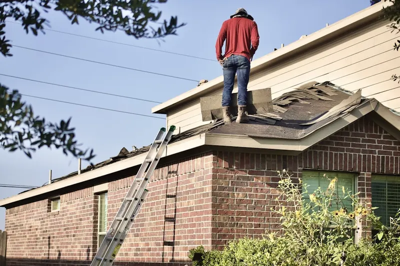 Professional roofer working on a residential roof in River Colony Northwest